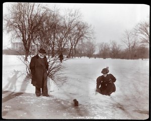 View of a Woman Feeding a Squirrel While a Man Looks On in the Snow at Central Park, New York